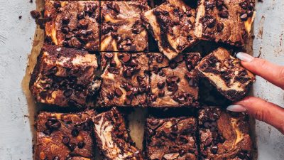A tray of brownies with cheesecake marbled through.